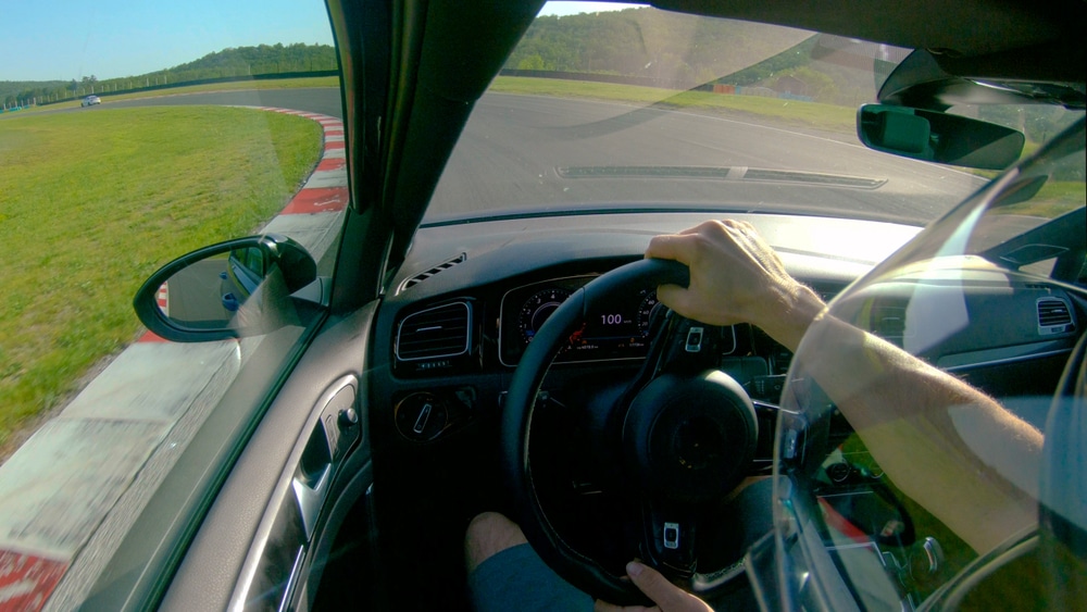 POV of a car driver making laps around a race track.